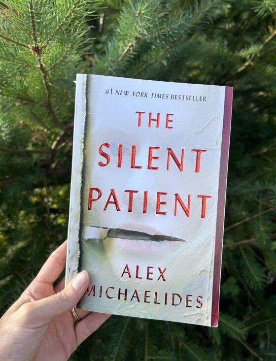The Silent Patient held up in front of tree