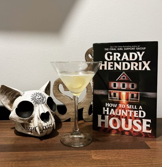 How to Sell a Haunted House and a Holland House cocktail on a table with Halloween decorations around.