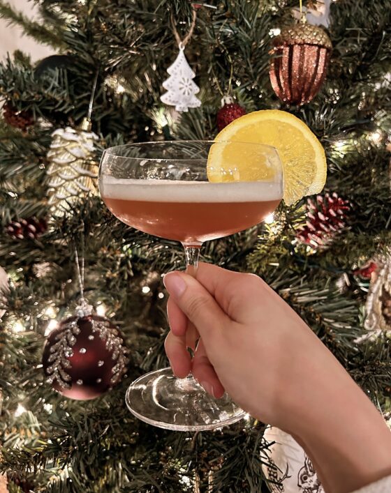 Wedding Bells cocktail being held up in front of a Christmas tree.