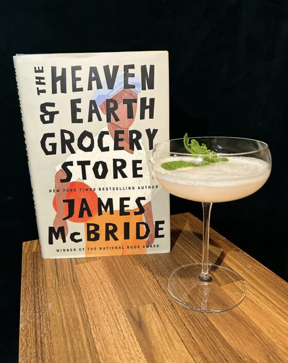 The Heaven and Earth Grocery Store on a wood table beside a seventh heaven cocktail.